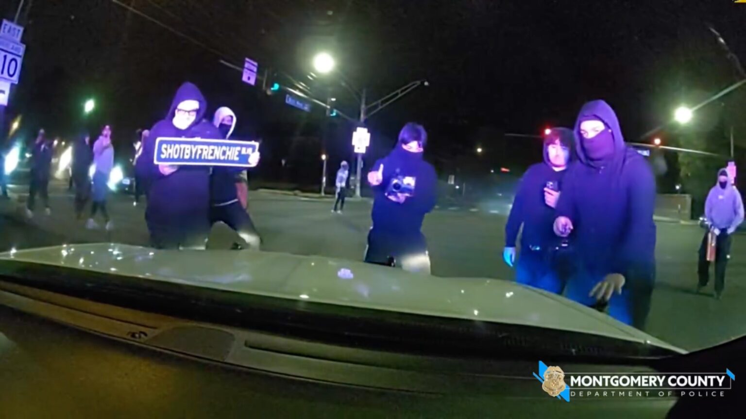 Masked mob attacks police cruiser with officer inside during illegal street takeover